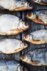 Salty dry river fish on a brown wooden background.