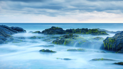Long exposure of mystery ocean and rocks. Tropical landscape with surreal stones on sea beach....