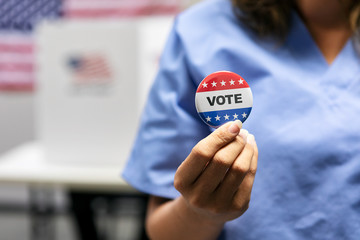 Election: Nurse Holds Up Vote Button After Voting