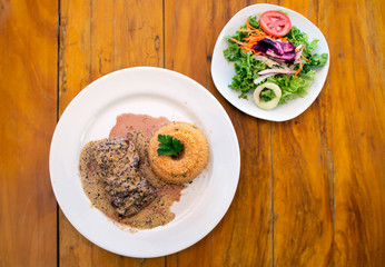 Steak au poivre or Pepper Steak served with quinoa and a fresh salad