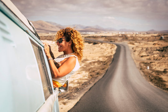 Woman with sunglasses leaning out the window of a van