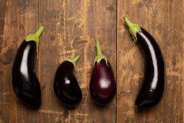 Freshly picked raw eggplants on dark rustic wooden background