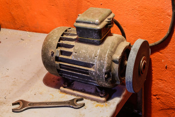 Grinding machine in the workshop. Wrench on the table