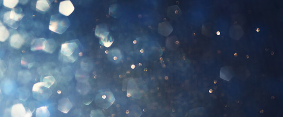 background of abstract glitter lights. blue, gold and black. de focused. banner