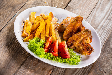 Grilled chicken wings, chips and vegetables