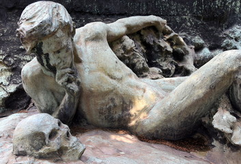 Liegender nackter Mann, der einen Totenschädel betrachtet