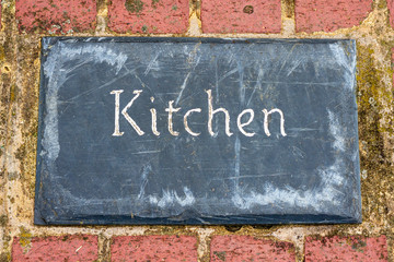 Fototapeta na wymiar Sign saying kitchen on a brick floor