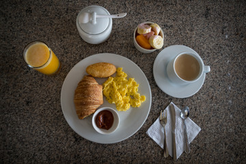 Ecuadorian breakfast. Cup of coffee, scrambled eggs, bread, pie, sweet and fruits