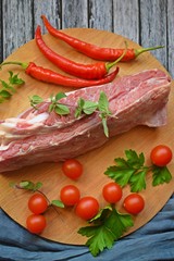 Fresh raw meat and pepper on a wooden background.