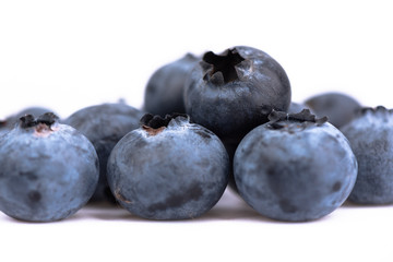 Macro shot. Blueberry berries in a wooden spoon over white background.
