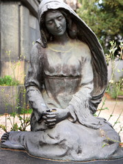 Fototapeta na wymiar Auf dem Friedhof sitzende Trauernde