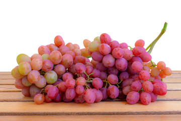 A bunch of grapes on wooden boards.