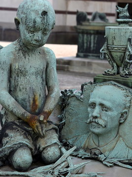 Skulptur eines trauernden Kindes am Grab des Vaters