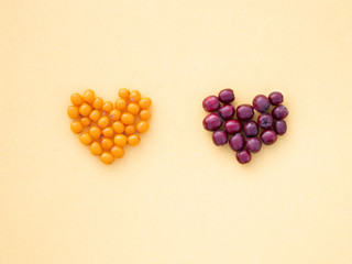 Sea buckthorn and Rowan berry hearts on yellow background love autumn