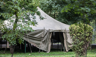 camouflaged green military tent in the forest