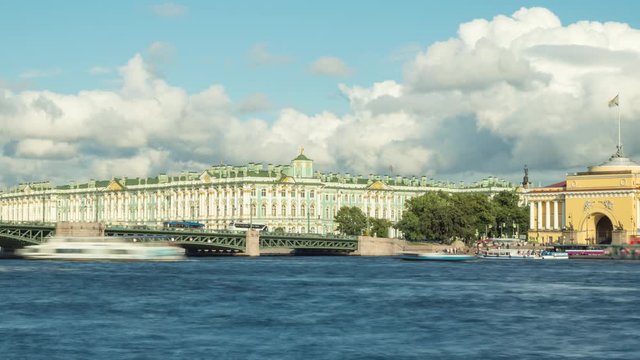 Dramatic cloudy sky over the Bridge and Winter Palace with boats on the Neva River. Saint Petersburg, Russia.