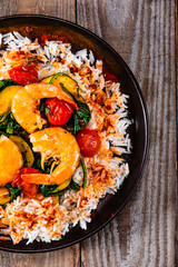 Shrimps with white rice and vegetables on wooden table
