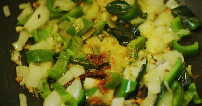 Slow motion shot of cooking a simple and easy vegetarian curry.