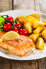 Fried salmon with baked potatoes and vegetables