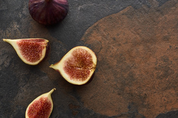 top view of ripe whole and cut delicious figs on stone background