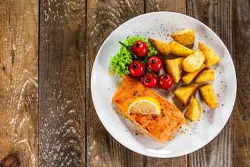 Fried salmon with baked potatoes and vegetables