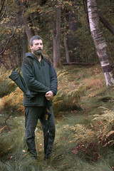 adult Caucasian man with a beard in casual clothes for a walk in the autumn forest