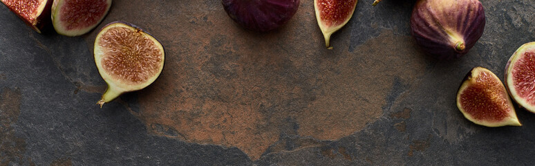 panoramic shot of ripe fresh whole and cut figs on stone textured background