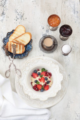 Cereal cereal with berries for breakfast in a beautiful ceramic plate. A concept of healthy and delicious nutrition. View from above.