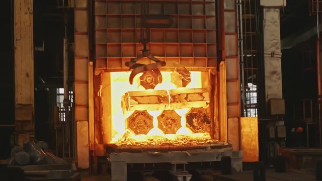 Work tick-borne crane at an engineering plant. The crane lifts the hot steel billets to move into the forging press.