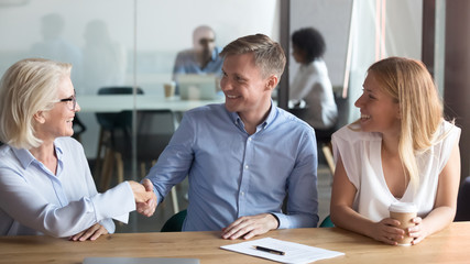 Happy husband handshake female realtor closing successful deal