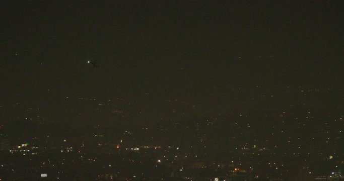 Night Time View Of A Helicopter Over LA From Kenneth Hahn Park In Los Angeles, California