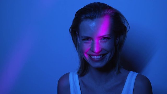 Beautiful Model in Front of Wall Laughing While Inside Dark Room