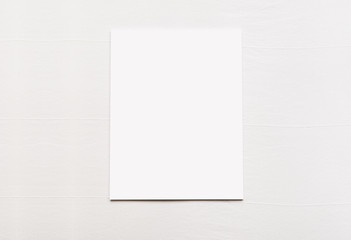Blank sheet of paper on white fabric linen background