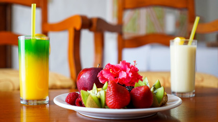 Plato de fresas y manzanas con bebidas