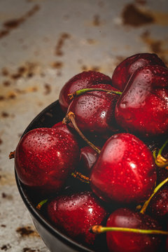 From above tasty appetizing ripe cherry in black brown shining under sunlight on rustic background