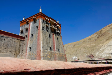 CLOSE UP: Large ancient Mongolian fort towers into the clear blue sky in Tibet.