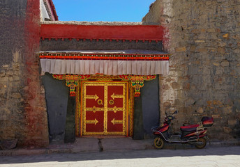 CLOSE UP: Old red motorbike is parked by the entrance to an incense factory.