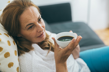 close up shot of beautiful middle aged woman drinking coffee or tea