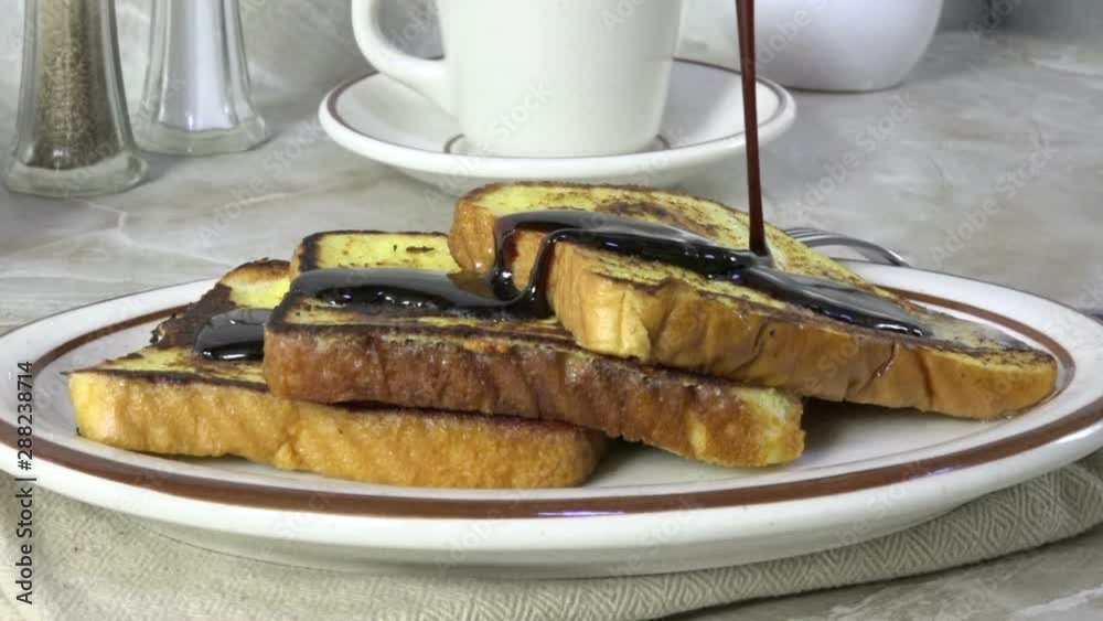 Wall mural Pouring syrup over french toast, slow motion