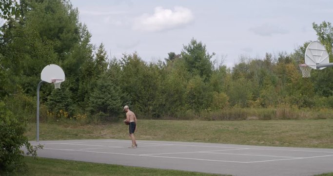 Man Playing Basketball on Outdoor Court Shooting Missing and Scoring Net