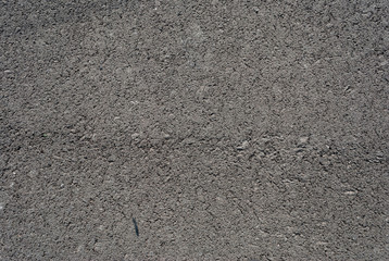 Smooth asphalt road. Tarmac dark grey grainy road background. Top view grunge rough surface