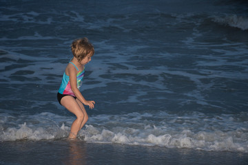 Little girl jumping ocean wave