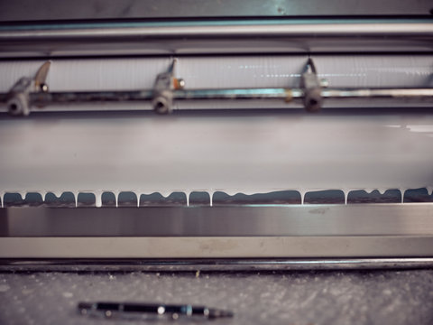 Closeup of gluing machine in process of working in printing house