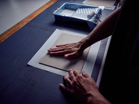 Bookbinder imposing fabric on cover for book