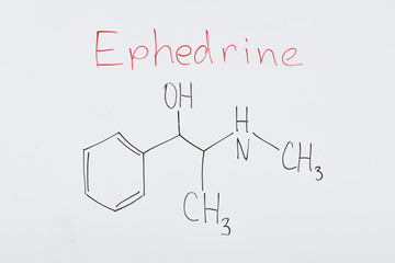 top view of white board with chemical formula and lettering ephedrine