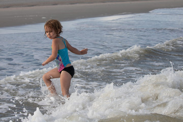 Young girl scared of ocean wave