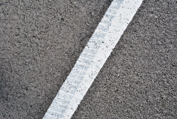 Asphalt texture with white line and tire marks . Top view