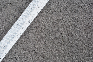 Asphalt texture with white line and tire marks . Top view