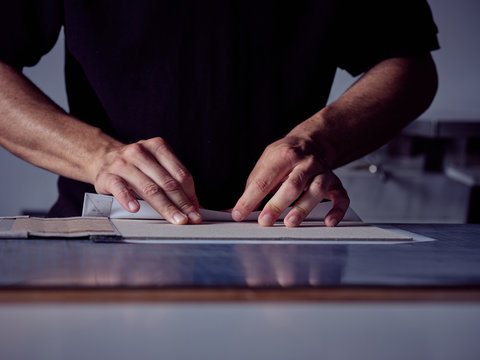 Bookbinder imposing fabric on cover for book