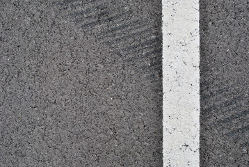 Fototapeta premium Asphalt texture with white line and tire marks . Top view